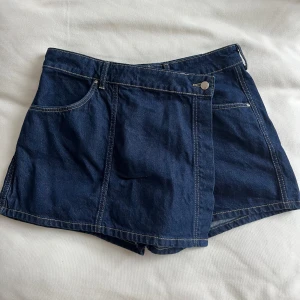 Mörkblå jeansshorts från Zara - Snygga mörkblå jeansshorts från Zara med klassisk femficksdesign och knappstängning. Perfekta för en avslappnad stil. De har en rak passform och är tillverkade i ett slitstarkt denimtyg.