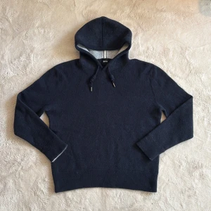 Kashmir hoodie  - Säljer en stilren mörkblå hoodie från Boss. Tröjan har en klassisk design med ribbade detaljer och justerbar huva med snören. De är en M men sitter åt S hållet. Perfekt för en avslappnad och trendig look. Hör av dig vid funderingar och pris kan diskuteras vid snabb affär mvh Malte.202