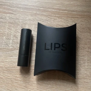 Läppbalsam från Lips of Sweden - Elegant läppbalsam från Lips of Sweden i en stilren svart förpackning. Perfekt för att ge dina läppar en sofistikerad look. Kommer i en matchande svart kartong. Oanvänt!