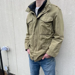 Grön jacka från Dobber - Säljer en stilren grön Fieldjacka från Dobber. Jackan har en dragkedja och knappar framtill, samt praktiska fickor. Perfekt för vår och höst. Jackan är lite stor på mig, men är i storlek Small, sitter dock som en Medium. Hör av er vid frågor!👍