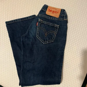 Levi's jeans i mörkblå denim - Snygga Levi's jeans i mörkblå denim med klassisk femficksdesign och knappgylf. Bootcut skulle jag säga 