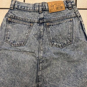 Jeanskjol från Wrangler  - Säljer en klassisk jeanskjol från Wrangler i blå denim. Kjolen har en rak passform med fem fickor och bälteshällor. Perfekt för en avslappnad stil. 🧢👖66 cm midja, bomull 