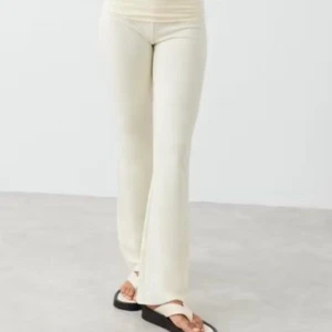Gina Yoga pants  - Snygga beige ribbade byxor med bootcut-stil. De är lågmidjade och har en skön passform som passar perfekt för en avslappnad look. Perfekta för vår och sommar!xs/m