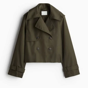 Trench coat HM grön - Jättesnygg populär trench coat jacka från HM i färgen mörk khakigrön, helt slutsåld på hemsidan!! Helt ny och prislapp sitter kvar🥰🥰 Pris går att diskutera💓