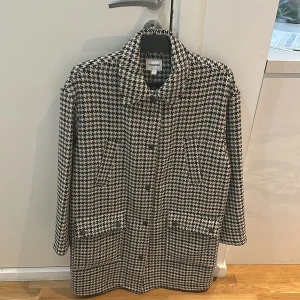 Svartvit rutig kappa från Monki - En  kappa i storlek s är från kappahl är inte använd och är  väldigt fin.