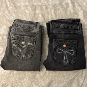 Svarta och grå jeans med broderade fickor - Två par jeans i svart och grått med unika broderade detaljer på bakfickorna. Båda paren har en klassisk femficksdesign och knappstängning. Perfekta för en stilren look med en twist. De gråa är i storlek 158 och de svarta är i storlek 164 båda är från Gina Young bara att skriva om ni undrar något eller vill ha fler bilder (vill ni bara ha ett par skriv till mig så fixar jag det kostar 199kr)❤️❤️💕💕
