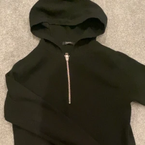 Svart hoodie med halfzip från Jack & Jones - Snygg svart hoodie från Jack & Jones med dragkedja framtill. Den är i ett skönt stickat material och är väldigt varm, perfekt till våren. Den är från Jack and Jones premium och ny priset är runt 700.  Rekommenderas till dig som är 170-180