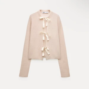  kofta från Zara - Säljer en stilren kofta från Zara med dekorativa rosetter framtill. Koftan har långa ärmar och en mjuk, bekväm passform. Perfekt för att lägga till en touch av elegans till din outfit. Om du är intresserad kontakta för bilder och info!