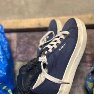 Blå sneakers från Gant - Snygga blå sneakers från Gant med vit sula och snörning. Perfekta för en avslappnad stil. Skorna har en klassisk design med Gant-loggan på sidan.