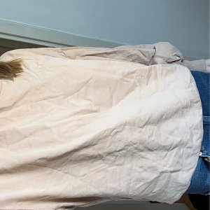 Beige långärmad tröja  - Säljer en stilren beige långärmad tröja i normal passform. Perfekt för en avslappnad look. Skjortan har en klassisk design och är lätt att matcha med olika outfits.