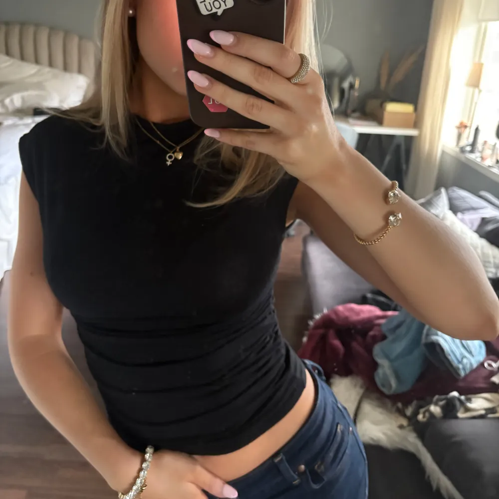 Säljer en stilren svart tight topp med korta ärmar. Perfekt för en enkel och snygg look. Passar bra till jeans eller kjol.. Yläosat.