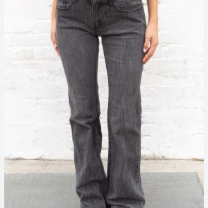 Grå bootcut jeans - Snygga grå bootcut jeans med låg midja från Brandy Melville. SKRIV VID FRÅGOR OM MÅTT!Jätte bra skick , inga defekter. Nypris 800kr. Skrev 36 som storlek med funkar jätte bra på 34 också⚠️⚠️🚨🚨‼️‼️
