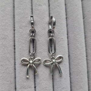 Silverörhängen med rosett - Charmiga silverörhängen med hängande rosett. Handgjorda örhängen●Följ :@ekjewelryofficial🤲 ●💎Material- metal och 100% rostfritt stål ●Örhängeskrokar -rostfritt stål. Nickel fri. Längd -5,5cm