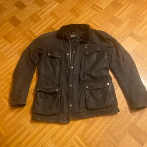 Barbour jacka - Säljer en svart vaxad jacka från Barbour. Jackan har en quiltad insida. Den är storlek small. Den är i gott skick. Den är använd men inte sliten. Fler bilder kan skickas.