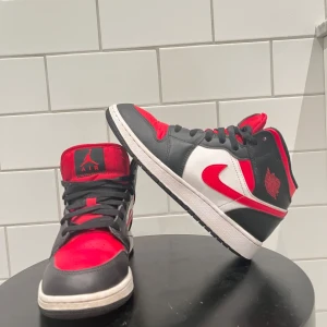 Nike jordans (Air Jordan 1 Mid 'Fire Red') - Snygga Nike Air Jordans i en klassisk färgkombination av svart, röd och vit. Skorna har en ikonisk design med snörning och det välkända Air Jordan-märket på sidan. Perfekta för dig som vill ha en stilren och sportig look. Pris kan diskuteras men inte mycket men rekommenderar skorna fick väldigt många komplimanger o skriv för mer information 🤩⭐️