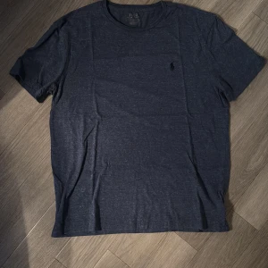 Ralph lauren T-Shirt  - Snygg mörkblå t-shirt från Ralph lauren  med en diskret broderad logga på bröstet. Perfekt för en stilren och avslappnad look. Ca 1000kr nypris mitt pris 199kr💯