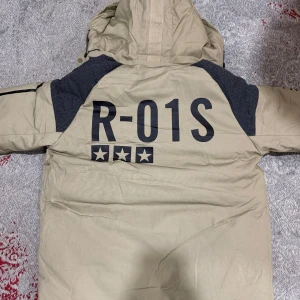 under armour jacka med päls - Säljer en beige parkajacka med textdetaljer och en mysig pälsfodrad Luva. Jackan har en dragkedja framtill och flera praktiska fickor. Perfekt för kyliga dagar. (NY) är inte använt 