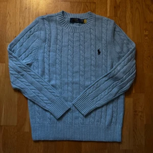 Ljusblå stickad tröja från Ralph Lauren - Säljer en stickad ljusblå Ralph lauren tröja. Skick är nyskick bara använd 1 gång😄. Finns inga defekter på tröjan och priset ej hugget i sten🪨