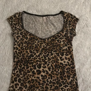 Leopardmönstrad topp - Snygg leopardmönstrad topp med korta ärmar och v-ringning. Perfekt för att lägga till lite djurmönster i garderoben. Toppen har en bekväm passform och är gjord i ett mjukt material.