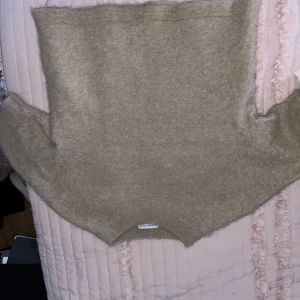 Beige tröja från & Other Stories - Säljer en mysig beige tröja från & Other Stories, perfekt för kyligare dagar. Tröjan har en enkel design med ribbade kanter och är i en mjuk och skön kvalitet. Passar bra till jeans eller kjol för en avslappnad look.