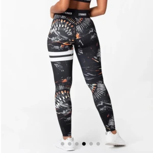 Mönstrade leggings från Stronger - Snygga leggings från Stronger med ett unikt mönster i svart, vitt och orange. Materialet är stretchigt och bekvämt, vilket ger en tight passform. Sportiga, bekväma, snygga😻😻Inga defekter. Original pris: 799kr