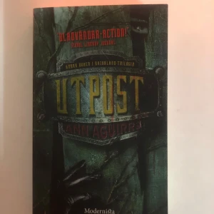 Utpost - Spännande bok i Razorland-trilogin av Ann Aguirre. Omslaget har en mörk och mystisk design med titeln i stora, gula bokstäver. Perfekt för dig som gillar actionfyllda berättelser.
