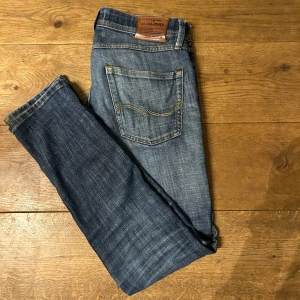 Blå jeans från Jack & Jones - Snygga blå jeans från Jack & Jones slim/glenn. Funkar för alla tillfällen har en skön liten slitning på höger ben. Är slim jeans och sitter gött. Har blivit något konstigt vid höger ficka men syns ej från håll. Skick 6/10 28w 30l