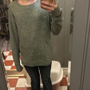 Grå stickad tröja från Vero Moda - Säljer en mysig grå stickad tröja från Vero Moda. Tröjan har en rund halsringning och långa ärmar, perfekt för kyligare dagar. Den är enkel och stilren, vilket gör den lätt att matcha med olika outfits. Perfekt för höst och vinter!