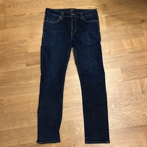 Neuw Jeans - Snygga mörkblå jeans från Neuw med klassisk femficksdesign och kontrastsömmar. Jeansen har en slim passform🪙🇫🇷