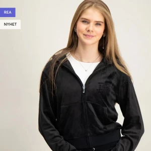 Svart hoodie med dragkedja - Snygg svart hoodie med dragkedja och huva. Tillverkad i ett mjukt material som ger en skön känsla. Perfekt för en avslappnad stil.