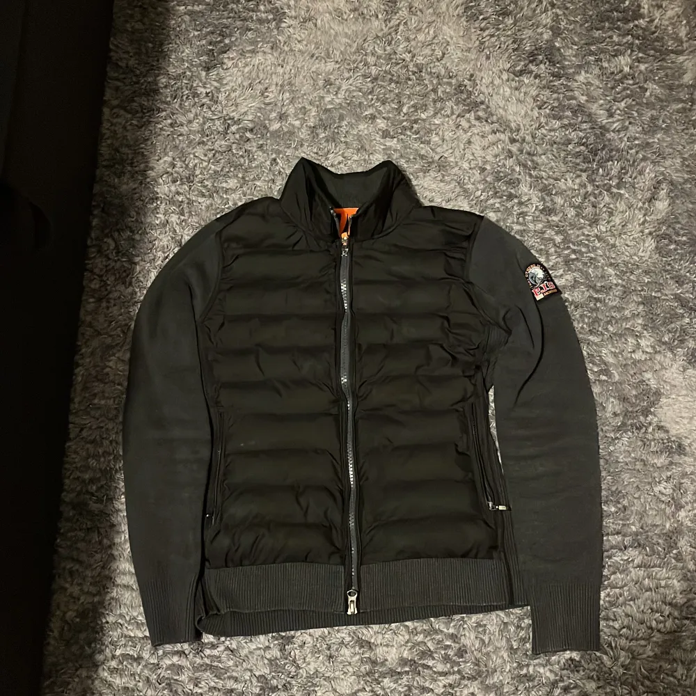 Snygg svart jacka från Parajumpers med quiltad framsida och dragkedja. Jackan har långa ärmar och en ribbad nederkant. Perfekt för kyligare dagar med sin stilrena design och bekväma passform.. Takit.
