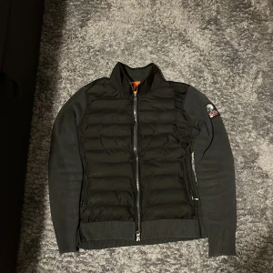 Svart jacka från Parajumpers - Snygg svart jacka från Parajumpers med quiltad framsida och dragkedja. Jackan har långa ärmar och en ribbad nederkant. Perfekt för kyligare dagar med sin stilrena design och bekväma passform.