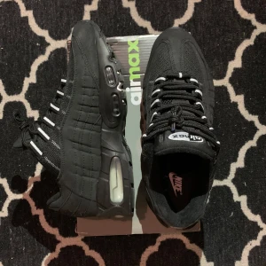Svarta Nike Air Max 95 - Säljer ett par svarta Nike Air Max 95s med reflex på baksidan och på tungan av skon i storlek 42. Enda tecken på användning är på sulorna och knappast, då dom bara har använts en gång. Vid frågor eller funderingar skicka ett pm, Mvh