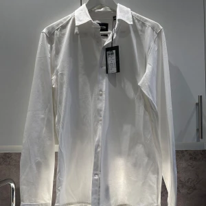 Vit långärmad skjorta från Only & Sons - Säljer en stilren vit långärmad skjorta från Only & Sons. Skjortan har en klassisk krage och knappar framtill. Perfekt för en elegant look. Pris går att diskutera hör av er vid frågor!🤩