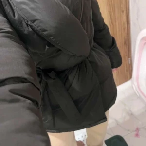 Svart dunjacka med knyt - Säljer en svart dunjacka med knyt i midjan. Jackan har en pufferdesign och långa ärmar, perfekt för kyliga dagar. Den är både stilren och funktionell, vilket gör den till ett måste i garderoben. 🖤, den är helt ny aldrig använd