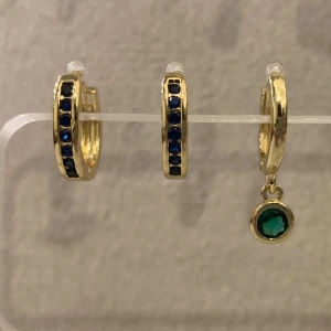 Guldplätarat örhängen med blå och grön sten - Snygga guldörhängen med blå stenar och en hängande grön sten på ett av örhängena. Perfekt för att ge en elegant touch till din stil.