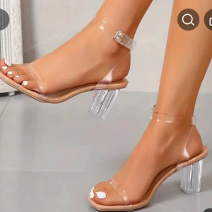 Transparenta klackskor med remmar - Snygga klackskor med transparenta remmar och klack. Skorna har en fyrkantig klack och en justerbar rem runt ankeln. Perfekta för en stilren look.
