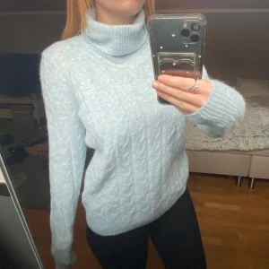 Ljusblå stickad polotröja - Mysig ljusblå stickad polotröja med kabelstickat mönster. 