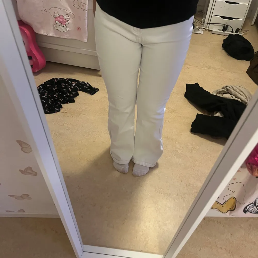 Snygga vita byxor med bootcut-stil. Perfekta för en stilren look. De har en hög midja som ger en smickrande passform.. Farkut & Housut.