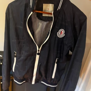 Blå vindjacka från Moncler - Säljer nu denna blåa moncler vindjacka. Jackan är typ 20 år gammal och har nästan aldrig kommit till användning. Inga kvitton finns därför priset. Storlek L i jackan men passar bra i längden 175. Pris kan diskuteras 