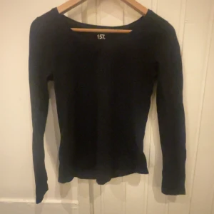 Svart långärmad topp från 157 - Säljer en stilren svart långärmad topp från 157. Tillverkad i mjuk bomull med en liten andel elastan för extra komfort. Perfekt till vardagen. Säljer då jag inte har använt