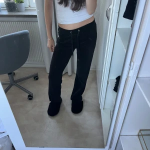 Svarta mjukisbyxor med snörning - Säljer ett par svarta mjukisbyxor som är superbekväma och perfekta för chill dagar hemma eller en snabb tur till affären. De har en snörning i midjan för att justera passformen och är i en loose stil. Materialet är mjukt och skönt, vilket gör dem till ett måste i garderoben!