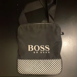 Boss väska  - Boss väska jättebra skick förutom att två bokstäver har ramlat av annars är den helt hel