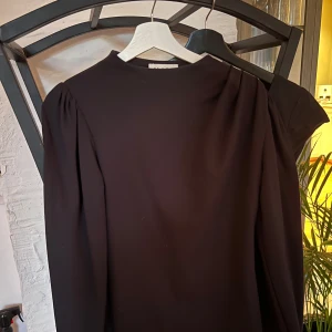 Långärmad tröja med snygga detaljer - Snygg tröja med långa ärmar och fina detaljer. Inte använd jättemycket. Sitter taight i armarna men en lösare passform på kroppen. 