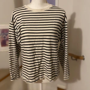 Randig tröja från Zara - Säljer en klassisk randig tröja från Zara i svart och vit. Tröjan har långa ärmar och en rund halsringning, perfekt för en stilren look. Tillverkad i ett mjukt material som ger en bekväm passform.