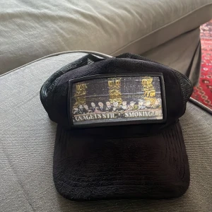 Svart keps med tryck - En riktigt snygg svart keps för både tjej och killar med ett AIK tifo som tryck. Kepsen är använde ett par gånger men endå ett bra skick 