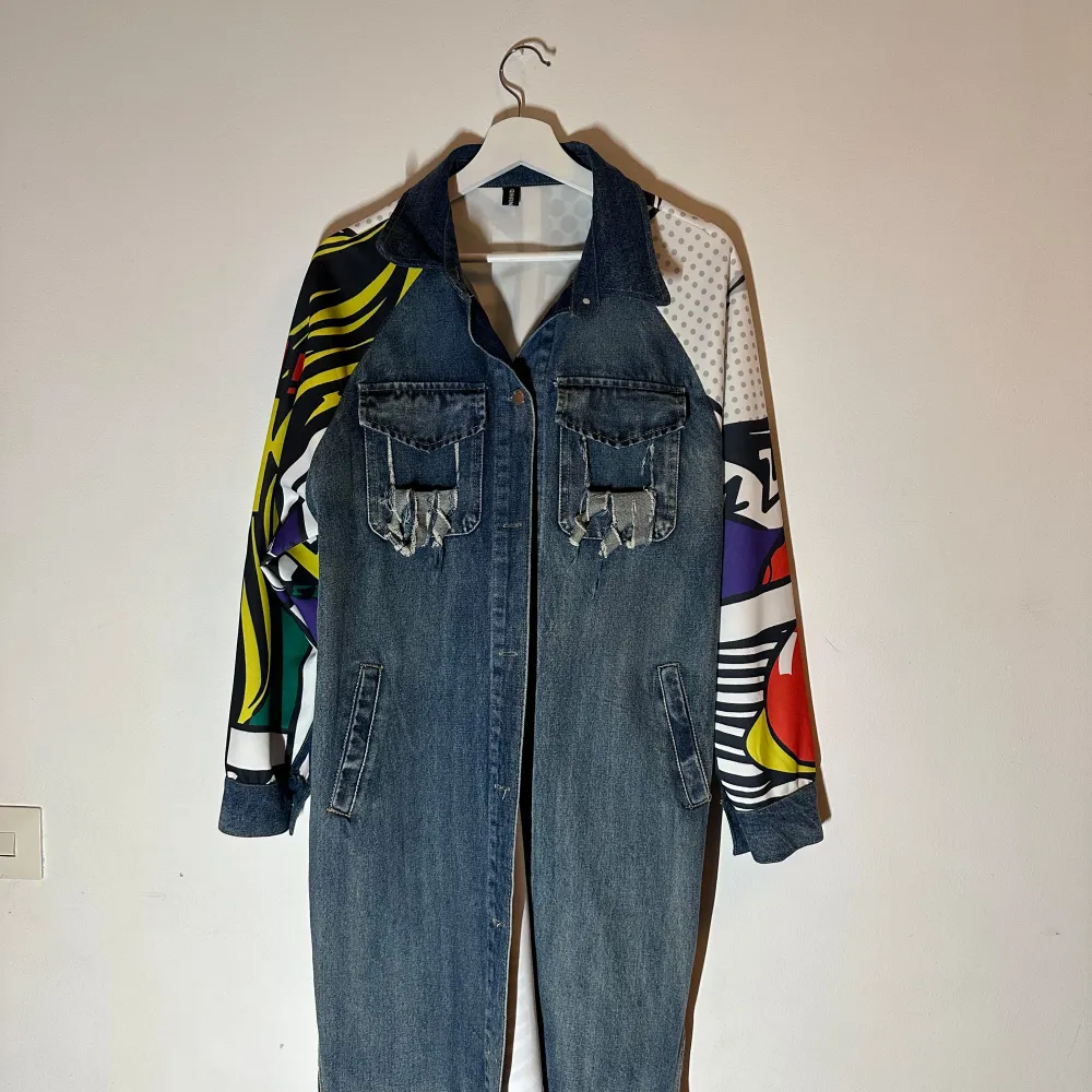 Unik jeansjacka från Moschino med färgglada, mönstrade ärmar i pop art-stil. Jackan har flera fickor fram och en cool design på baksidan. Perfekt för dig som vill sticka ut🥰🥰🥰. Takit.