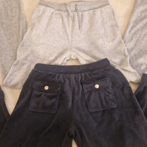 Juicy Couture mjukisbyxor i grått och mörkblå💗strl 11/12år(xxs) 600kr för båda pris kan diskuteras - Två par mjukisbyxor från Juicy Couture. Ett par i grått med snörning i midjan och ett par i mörkblå med fickor och knappar. Perfekta för en avslappnad stil.Den gråa har inga knappar där back utan bara fickor💗