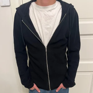Svart stickad hoodie - Stickad zip hoodie från Jack n Jones. Storlek S. Fint skick utan tecken på användning. Nypris ca 600kr. Hör gärna av dig! 