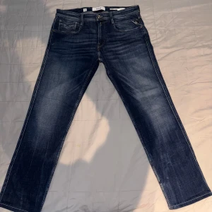 Mörkblå jeansbyxor - Snygga mörkblå jeansbyxor med en klassisk straight passform. Modellen på jeansen är anbass. Byxorna har en midwaist design och är utrustade med både dragkedja och knappar. Perfekta för en avslappnad stil.